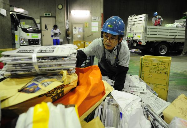 资料图：在日本东京都港区资源垃圾处理中心，工作人员在整理旧报纸。 （新华社）