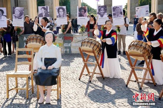 资料图片：8月14日，在德的韩国和日本民间团体于第七个世界“慰安妇”纪念日之际在柏林勃兰登堡门前举行集会，一座“和平少女像”出现在当天的活动现场。中新社记者 彭大伟 摄