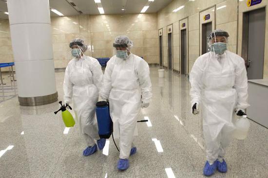 带着防护装备和消毒剂的官员准备在平壤国际机场检查从国外入境旅客的健康状况 图自美媒