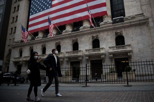 近日，戴口罩的行人从纽约证券交易所门口走过。新华社发