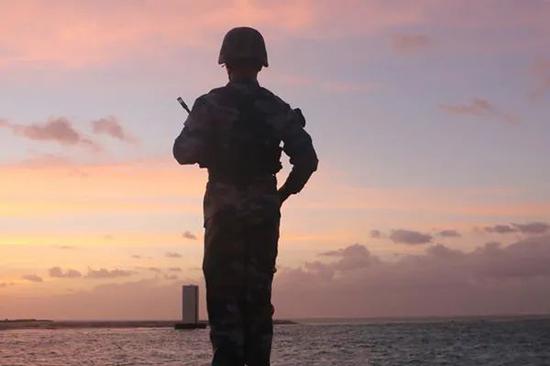 “南海第一哨”华阳礁守礁战士在站岗瞭望。图|新华社
