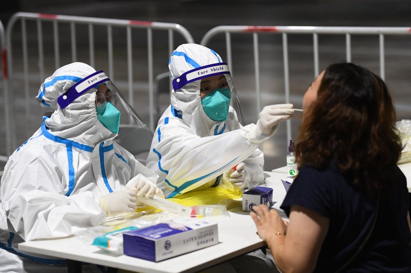 7月21日晚，在南京市玄武区一处检测点，医务人员在为市民进行核酸检测取样。新华社 图