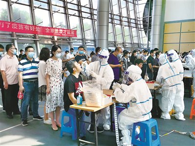  南京市江宁区在全区紧急设置551个临时核酸检测点，对全区范围内居民开展全员核酸检测。图为江宁区医护人员在临时检测点进行核酸采样。 摄影/胡重义（江宁区纪委监委干部）