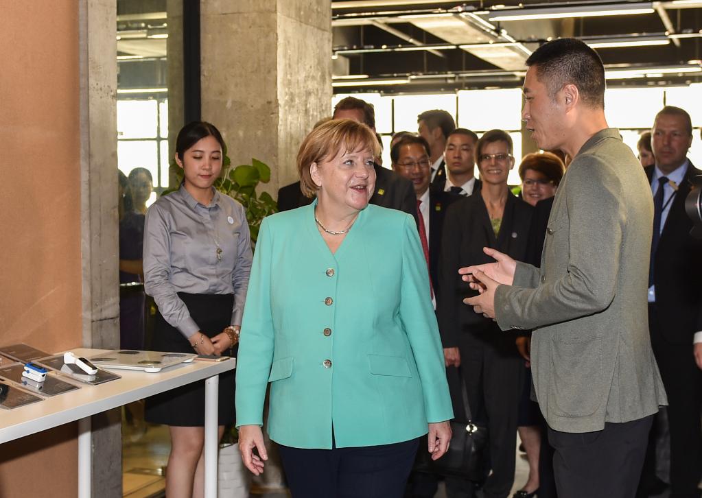 2018年5月25日，德国总理默克尔从北京飞抵深圳参观。这是默克尔（前左）在深圳本土初创型企业碳云智能科技有限公司参观。（新华社记者毛思倩摄）
